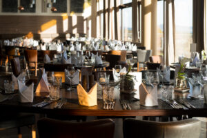 Ein großes Esszimmer mit Tischen und Stühlen, in dem Gäste zusammenkommen können, um eine Mahlzeit zu genießen und möglicherweise Freunde zu finden.