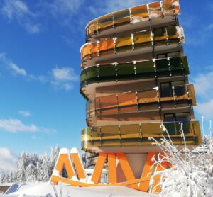 Ein Gebäude mit schneebedecktem Dach, perfekt, um während der Winterveranstaltung von AVIVA Freunde zu finden.