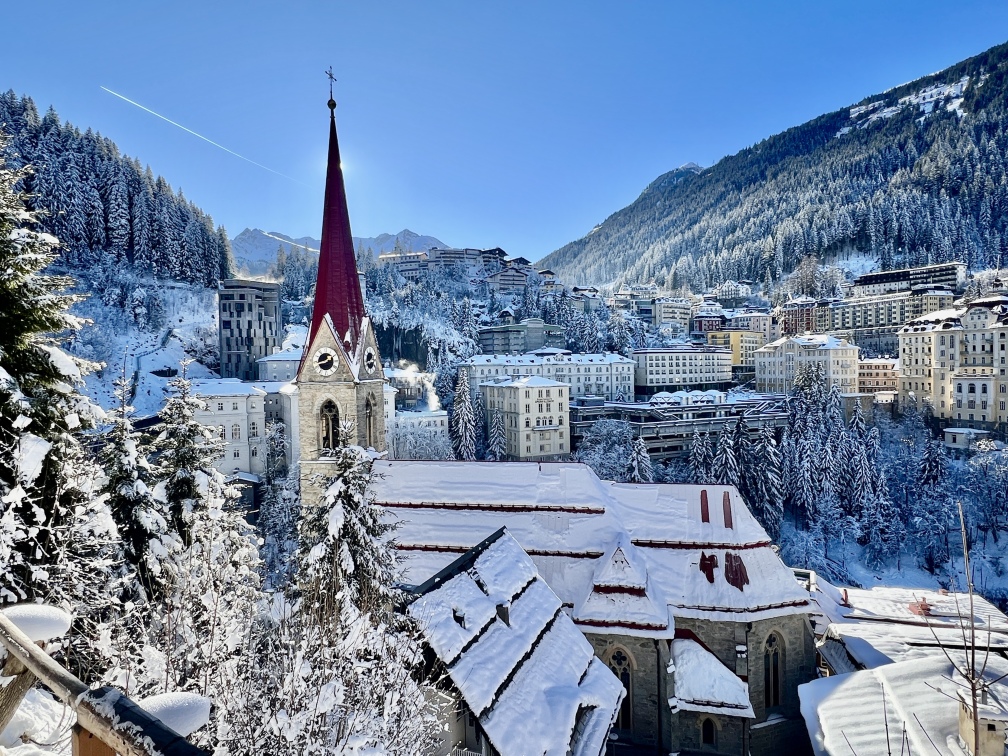 Eine Stadt in Bad Gastein mit einer schneebedeckten Kirche im Hintergrund.