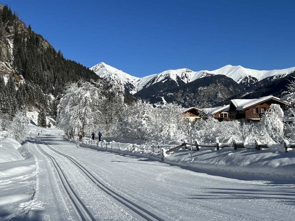 Eine schneebedeckte Straße in Bad Gastein mit Häusern im Hintergrund.