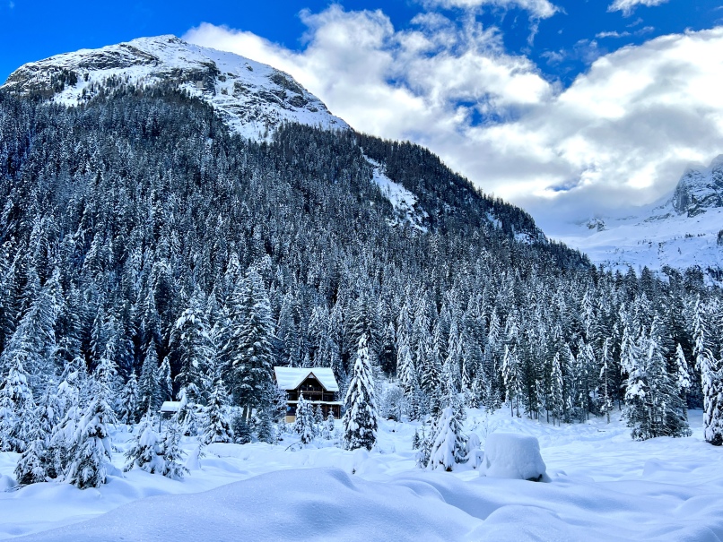 Eine Winterwanderungshütte, eingebettet in die schneebedeckten Kötschachtaler Berge und umgeben von Bäumen.