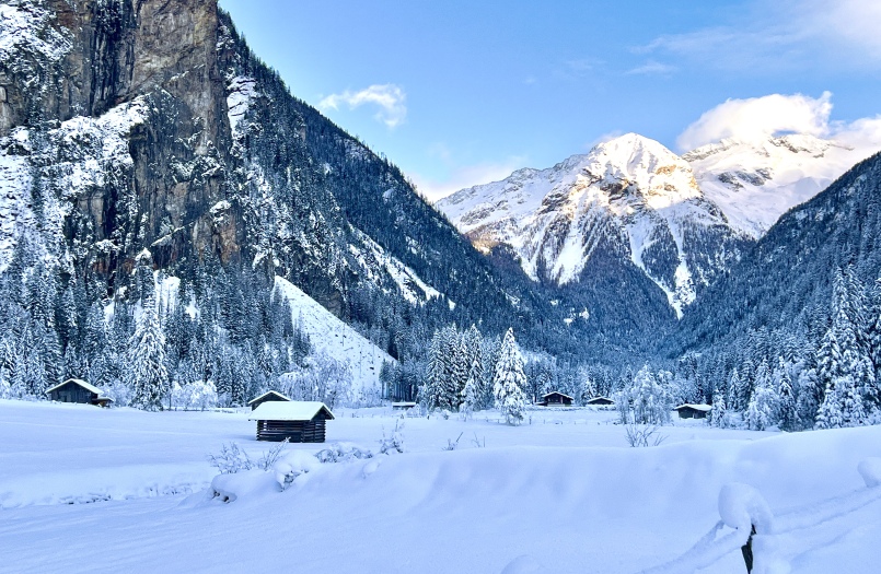 Eine Winterszene mit schneebedeckten Bergen und Hütten in Bad Gastein, Kötschachtal während einer Winterwanderung.